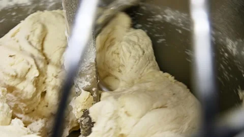 Dough mixer kneading bread dough in a stainless steel bowl, close-up view Stockbeeldmateriaal 335191378