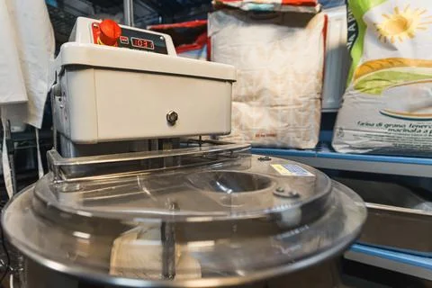 Dough mixer machine with scale surrounded by flour pockets in the kitchen Stock Photos