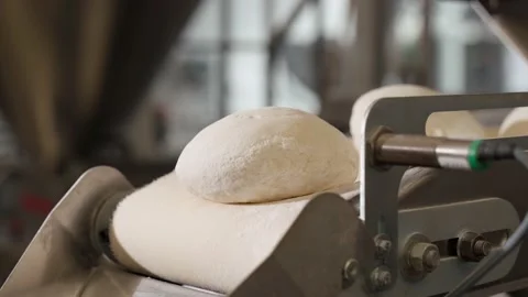 The dough moves along the conveyor. Bread production process. Bakery. Stock Footage 220878610