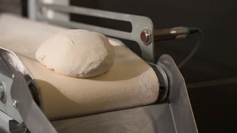 The dough moves along the conveyor. Bread production process. Bakery. 4k Stock Footage 221969241
