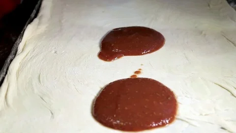 On the dough for pizza spread a large spoonful of red sauce Stock Footage 92331298