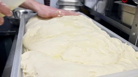 Dough preparation process with butter coating in commercial kitchen setting Stock Footage 337229062