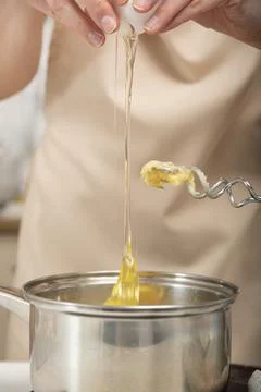 Dough preparation process. Cook adds eggs to the pot. Foto stock