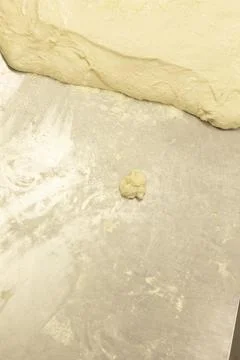 Dough resting on metallic baking surface in calm bakery setting top-down view. Stock Photos