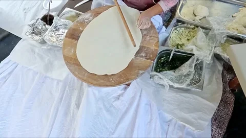 Dough is rolled out with rolling pin by women's hands 動画素材 163900228