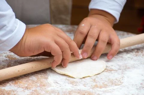 The dough rolling the the child hands. Stock Photos
