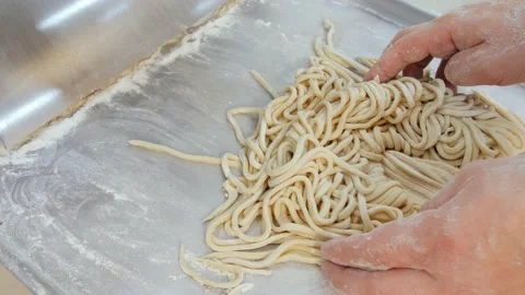 Dough sclicing machine. Man showing cutted dough for pasta Stock Footage 131825236