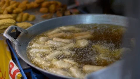 Dough sticks on boiling deep fat oil, asian street food, cooking doughnuts Stock Footage 71392324