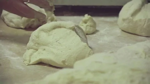 Dough at table on bakery HD video. Baker hands take dough. Bread production Stock Footage 74727792