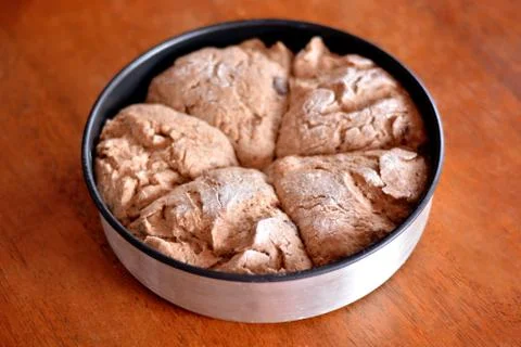 The dough on a tray on the table is ready for baking. Stock Photos