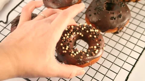 Doughnut on the baking rack glazed with chocolate cream or icing. Breakfast Stock Footage 145121770