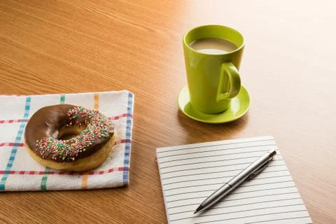 Doughnut coffee and notepad with pen Stock Photos
