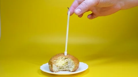 A doughnut with cream and a candle. Stock Footage 320574340