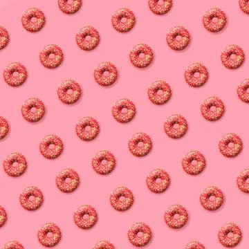 Doughnut pattern. The diagonal pattern of pink doughnuts lay flat on a pink b Stock Photos
