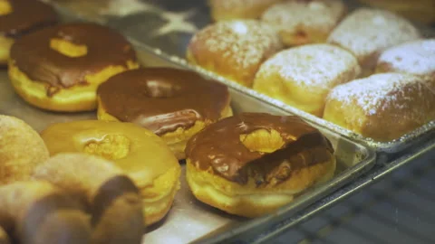 Doughnuts inside a glass display case at a bakery Stock Footage 131238606