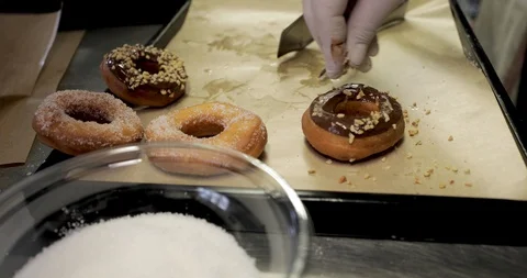 Doughnuts preparation, chocolate and chopped hazelnuts Stock Footage 129712603