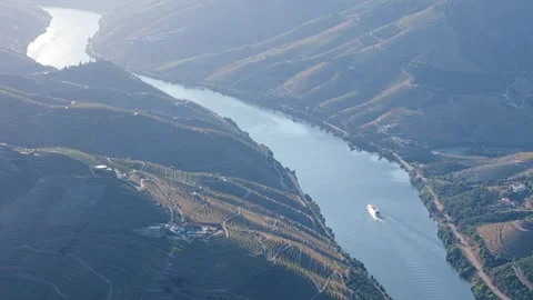 Douro River tourist boat below vineyard hills at sunset 動画素材 344288070