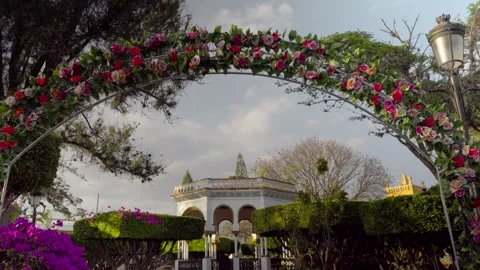 Dove flying Rose arch in Comitán's central park, Mexico, frames the kiosk and Stock Footage 308218045