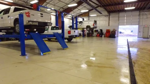 From down to up and zooming in shot inside automobile repair shop Stock-Footage 107928964