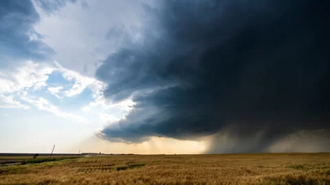 Down burst of rain falls beneath spinning storm cloud over beautiful fields Stock Footage 279926183