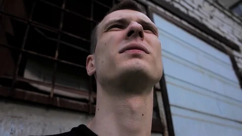 From Down to up the Courageous Face of a Young Man Against the Backdrop of Stock Footage 73597338