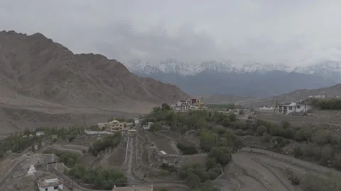 Down to Up Drone Reveal of Ladakh Monastery with Snow Covered Mountains in the Stock Footage 335751547