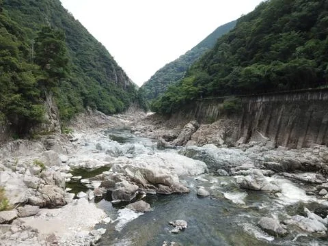 Down inside a gorge with a pathway next to it. Stock Photos