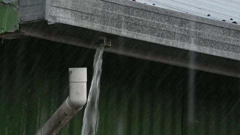 A down-pipe has become detached from the guttering, the rain is pouring thr.. Stock Footage 254757243