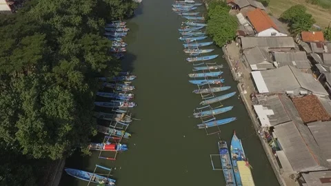 Down the river canal with rows of wooden fishing boats anchored. Stock Footage 154555450