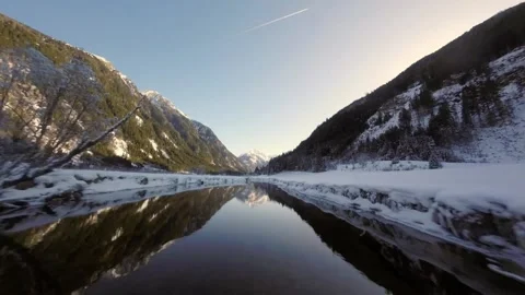 Down the river that reflects the mountains on the surface of river Stock Footage 152327756