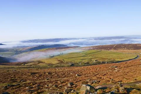 Down the slopes of Stanage Edge to a mist covered landscape Foto stock