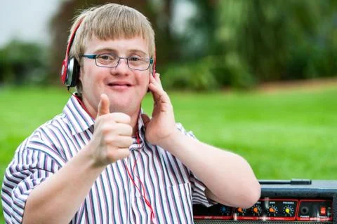Down syndrome boy with headset doing thumbs up. Foto stock