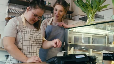 Down syndrome girl learning how to use a cash register Stock Footage 242598146