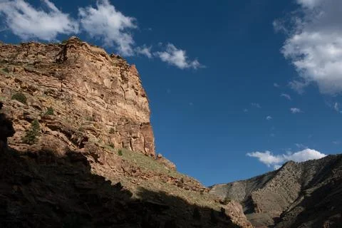 Down in the valley looking up at looming cliff face in Nine Mile Canyon, Utah Stock Photos