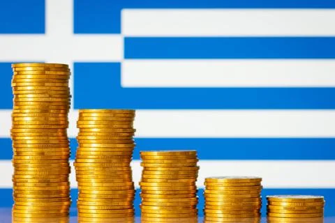 Downcomming graph made of gold coins against flag of Greece Stock Photos
