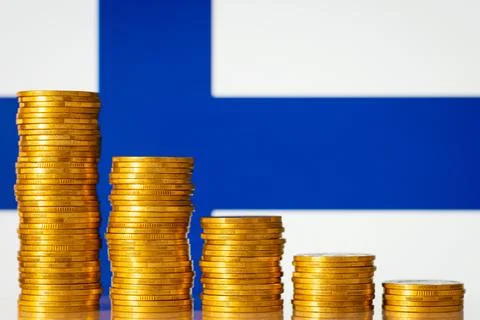 Downcomming graph made of gold coins against flag of Finland Stock Photos