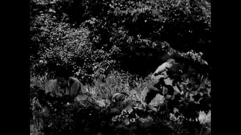 A downed airman dons a native hat and airmen view a map and plan an escape route Stock Footage 90459095