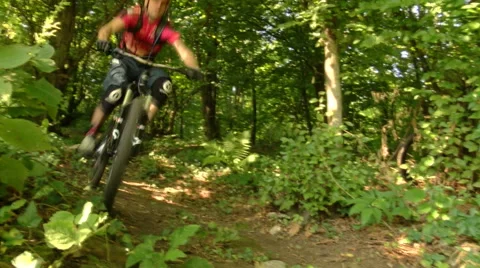 Downhill cyclist passing really close to the camera in full speed Stock Footage 55900772