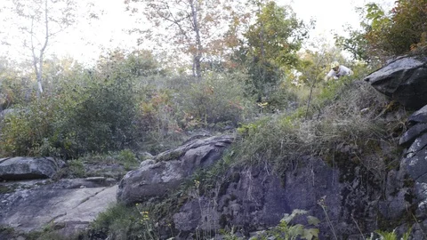 Downhill Mountain biker rides through rocks Stock Footage 88687497