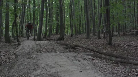 Downhill mountain biker on a trail, taking a jump. 스톡 동영상 53871796
