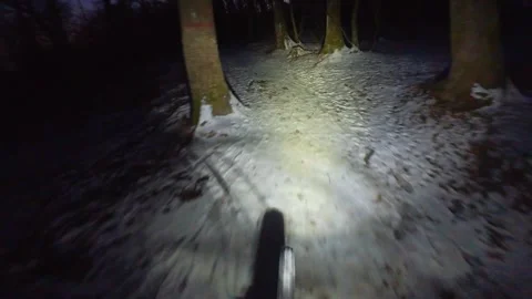 Downhill ride on a slippery mtb path in the forest on the night of winter with Stock Footage 251649366