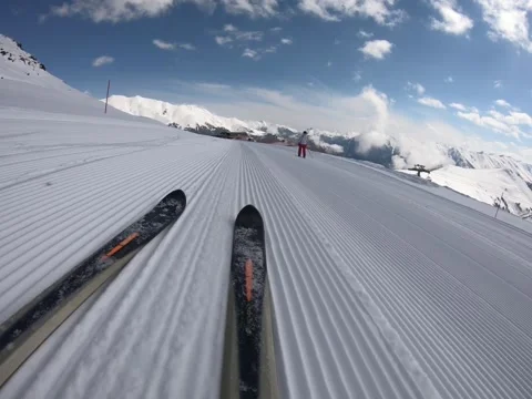Downhill skiing close-up glides along the corduroy of a squandered snowy slope Stock Footage 161099330