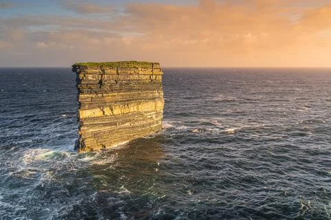 Downpatrick Head sea stack illuminated by sunrise, standing in Atlantic Ocean Foto stock