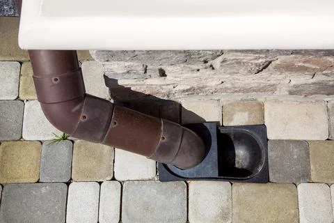 Downpipe made of brown pvc plastic drainage of rainwater. Stock Photos