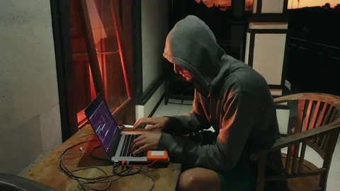 Downshifter Hacker programmer in a hood creates a new program with viruses. A Stock-Footage 158738605