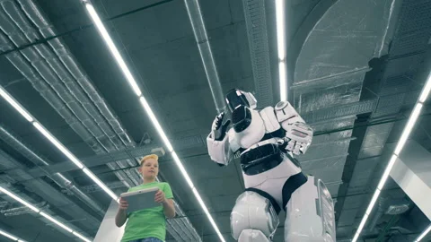 Downside view of a cyborg and a boy walking together Stock Footage 101981135