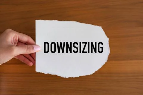 Downsizing Downsizing. Woman hand holds a piece of paper with a note, down... 库存照片
