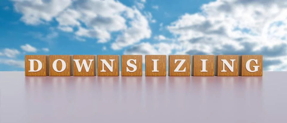 Downsizing. Downsizing. Wooden dices with white capital letters and the wo... 库存照片