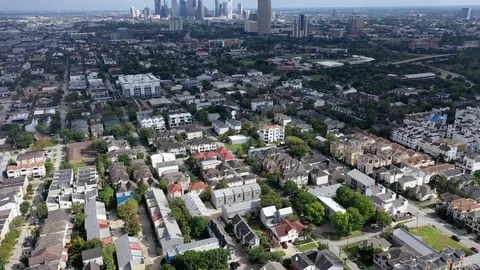 Downtown Houston skyline beyond dense townhome rooftops Vidéo 98011414