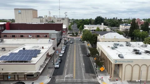 Downtown street intersection flanked by commercial buildings, a church and Video stock 337670251